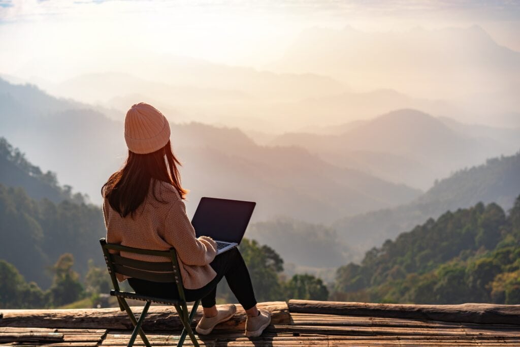 young,woman,freelancer,traveler,working,online,using,laptop,and,enjoying,workation