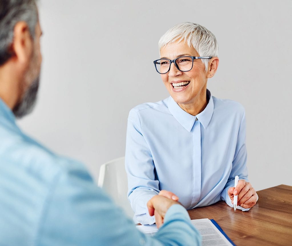 portrait,of,two,senior,business,people,shaking,hands,deal,or